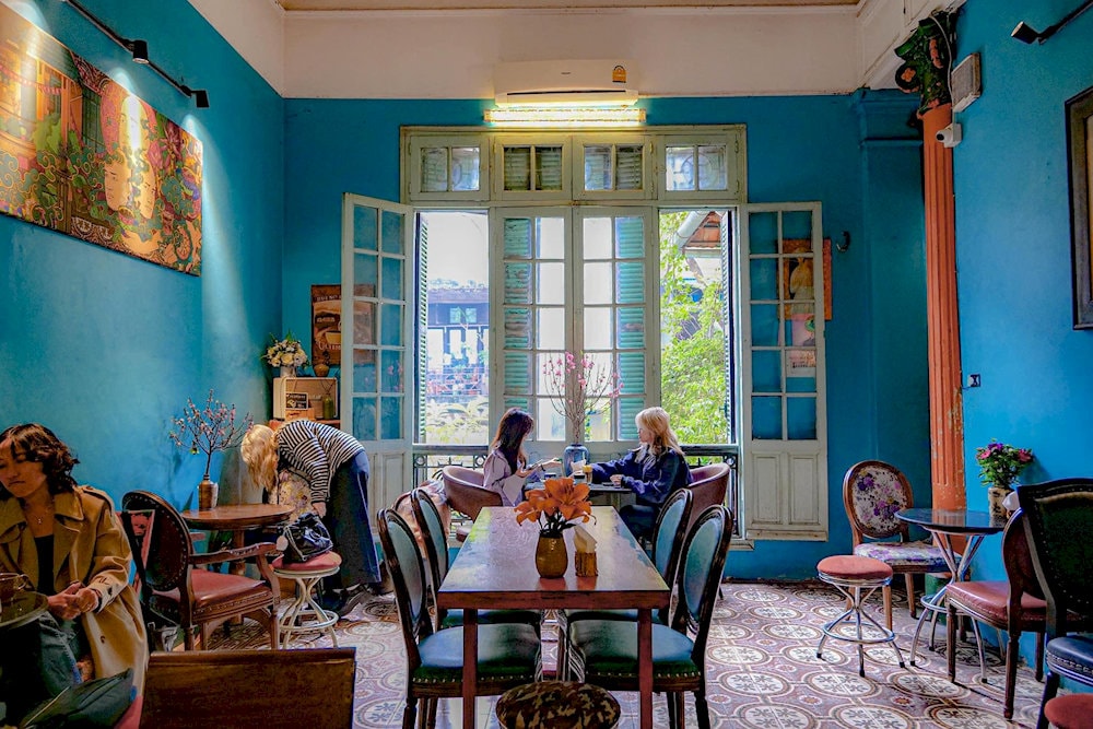 A cozy corner at Loading T Cafe filled with natural light and colorful flowers